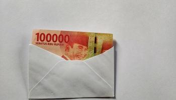 Indonesian rupiah banknotes worth IDR 100,000 in a white envelope isolated on white background photo