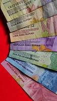 Billete indonesio de 1.000 a 100.000 rupias aislado sobre fondo rojo. vista de cerca foto