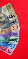 Portrait of Indonesian 1,000 to 100,000 rupiah banknote isolated on red background. photo