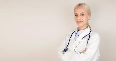 Copy space banner with young doctor against gray background looking at camera and smiling photo