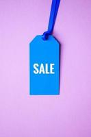 etiqueta de precio azul con palabra de venta en el fondo rosa, maqueta azul foto
