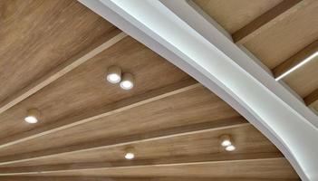 Techo de tablones de madera con lámparas de tiras de led. idea para un diseño de techo de tablones de madera para un interior de estilo loft. la textura de las tablas de madera. foto
