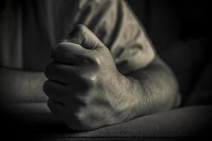 A closeup of a clenched male fist in black and white photo