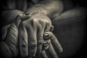 A close-up of man and woman holding hands in black and white photo