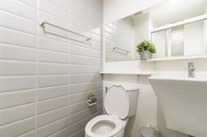 Loft white tile public bathroom corner, tub and sink photo