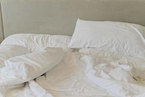 Unmade bedding sheets and pillow. Unmade messy bed after comfortable sleep concept photo