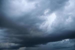 Storm clouds floating in a rainy day with natural light. Cloudscape scenery, overcast weather above blue sky. White and grey clouds scenic nature environment background photo