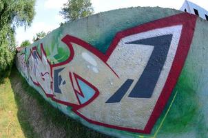 Street art. Abstract background image of a full completed graffiti painting in chrome fill, green background and red outlines. Fisheye photo