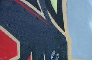 Street art. Abstract background image of a fragment of a colored graffiti painting in dark grey and red tones photo