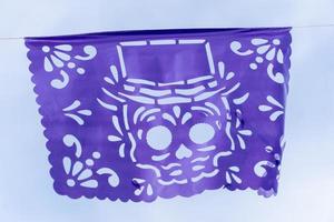 decoration day of the dead, purple and yellow papel picado, sky background, mexico photo