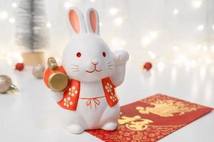Chinese Lunar New Year concept. Greeting for Chinese Rabbit New Year with red envelope. The Chinese word means happiness or good fortune. photo