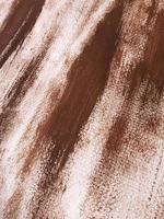 pintura abstracta acrílica o gouache marrón sobre papel de lienzo texturizado. pinceladas de pintura marrón oscuro. Fondo artístico de perspectiva diagonal vertical con lugar para texto. enfoque selectivo, primer plano. foto