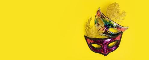 Two festive face mask for carnival celebration on colored background. Carnival flat lay concept photo