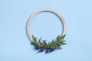 Round wooden frame with flower and leaves mock up flat lay for your text photo