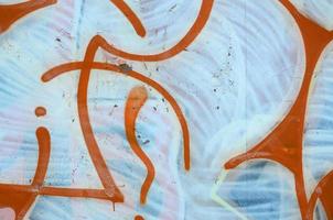 Street art. Abstract background image of a fragment of a colored graffiti painting in white and orange tones photo