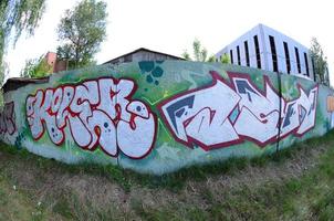 Street art. Abstract background image of a full completed graffiti painting in chrome fill, green background and red outlines. Fisheye photo