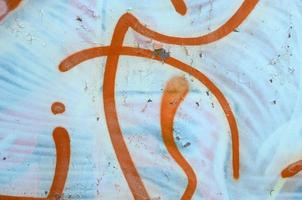 Street art. Abstract background image of a fragment of a colored graffiti painting in white and orange tones photo