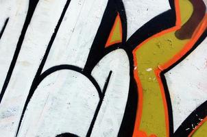 Street art. Abstract background image of a fragment of a colored graffiti painting in white and orange tones photo