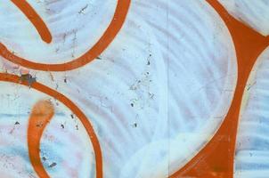 Street art. Abstract background image of a fragment of a colored graffiti painting in white and orange tones photo