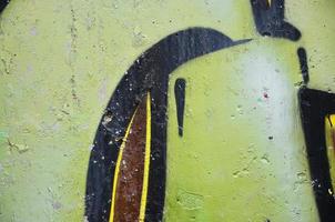 Texture of a fragment of the wall with graffiti painting, which is depicted on it. An image of a piece of graffiti drawing as a photo on street art and graffiti culture topics