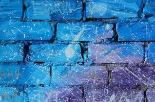 la textura de la antigua pared de ladrillo, pintada en colores azul y púrpura con gotas blancas descuidadamente espaciadas y salpicaduras que visualizan las estrellas en el espacio ultraterrestre