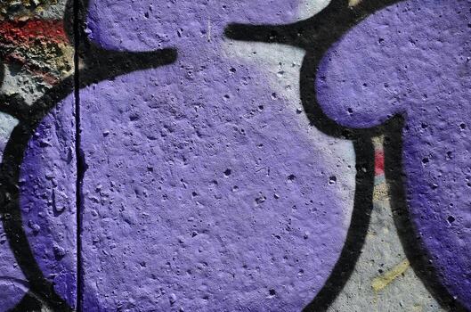 Texture of a fragment of the wall with graffiti painting, which is depicted on it. An image of a piece of graffiti drawing as a photo on street art and graffiti culture topics