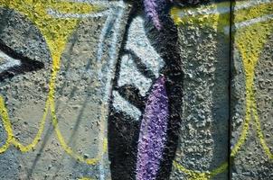 Texture of a fragment of the wall with graffiti painting, which is depicted on it. An image of a piece of graffiti drawing as a photo on street art and graffiti culture topics