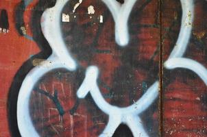 Texture of a fragment of the wall with graffiti painting, which is depicted on it. An image of a piece of graffiti drawing as a photo on street art and graffiti culture topics