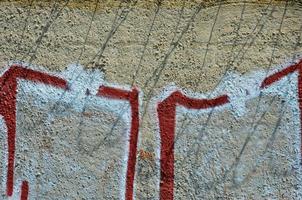 Texture of a fragment of the wall with graffiti painting, which is depicted on it. An image of a piece of graffiti drawing as a photo on street art and graffiti culture topics