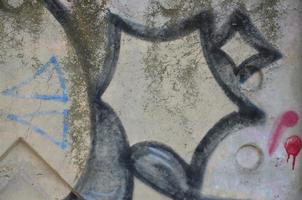 Texture of a fragment of the wall with graffiti painting, which is depicted on it. An image of a piece of graffiti drawing as a photo on street art and graffiti culture topics