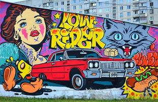 una imagen detallada del dibujo de graffiti. fondo de arte callejero conceptual con personajes de dibujos animados, una chica retro, un bozal de gato malvado, graffiti de letras, perrito caliente, dados y un coche lowrider rojo foto