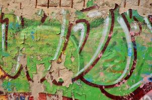 Detailed image of very old and aged color graffiti drawing on the wall. Background grunge street art picture photo