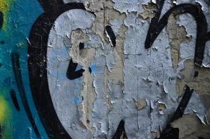 Detailed image of very old and aged color graffiti drawing on the wall. Background grunge street art picture photo