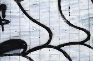 A fragment of a graffiti pattern, applied to a wall of cold tiles, which is covered with a fine condensate. The concept of street art in inappropriate weather photo