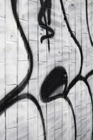 A fragment of a graffiti pattern, applied to a wall of cold tiles, which is covered with a fine condensate. The concept of street art in inappropriate weather photo