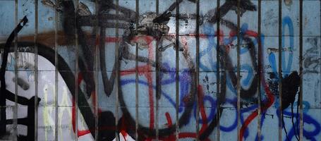 A fragment of graffiti drawing and a set of tags applied to the wall from the old tile in the subway tunnel. The concept of street art and vandalism photo
