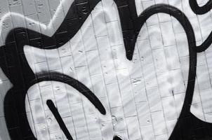 A fragment of a graffiti pattern, applied to a wall of cold tiles, which is covered with a fine condensate. The concept of street art in inappropriate weather photo