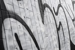 A fragment of a graffiti pattern, applied to a wall of cold tiles, which is covered with a fine condensate. The concept of street art in inappropriate weather photo