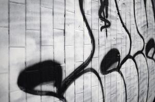 A fragment of a graffiti pattern, applied to a wall of cold tiles, which is covered with a fine condensate. The concept of street art in inappropriate weather photo