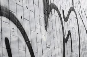 A fragment of a graffiti pattern, applied to a wall of cold tiles, which is covered with a fine condensate. The concept of street art in inappropriate weather photo