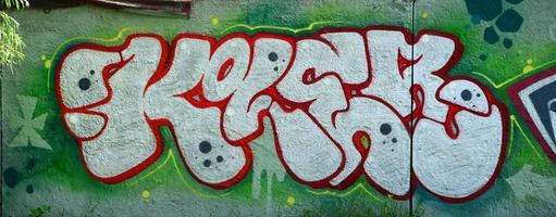 arte callejero. imagen de fondo abstracta de una pintura de grafiti completa con relleno cromado, fondo verde y contornos rojos foto