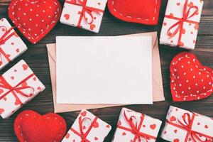 Envelope Mail with Red Heart and gift box over Dark Wooden Background. Valentine Day Card, Love or Wedding Greeting Concept photo