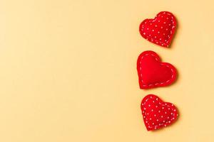 Composition of textile red hearts on colorful background with empty space for your design. Top view of St. Valentine's day concept photo