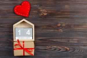 Cube calendar with red heart and gift box on wooden table with copy space. 14 February concept photo