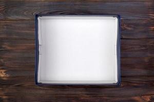 Empty opened white cardboard box for mock up on dark wooden table with copy space photo