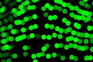 Unfocused abstract green bokeh on black background. defocused and blurred many round light photo