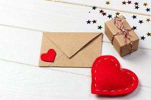 love letter envelope with red heart and gift box on wooden background photo