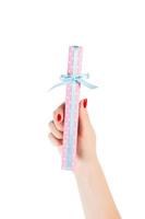 Woman hands give wrapped Christmas or other holiday handmade present in pink paper with blue ribbon. Isolated on white background, top view. thanksgiving Gift box concept photo