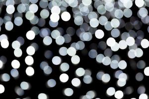 Unfocused abstract white bokeh on black background. defocused and blurred many round light photo