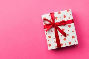 Background with gift box and hearts on pink Background. Top view with copy space for text photo